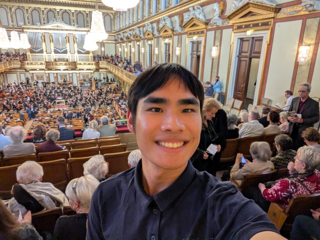 A student smiling with in  a concert hall.
