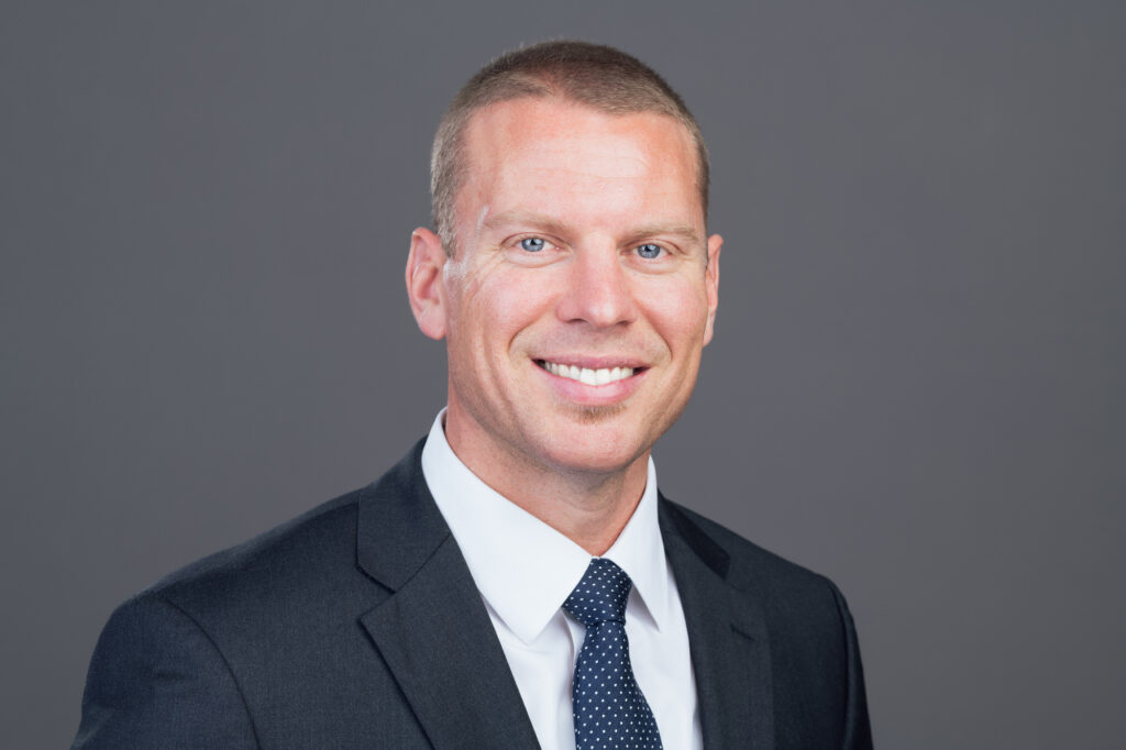 A man in a suit smiling